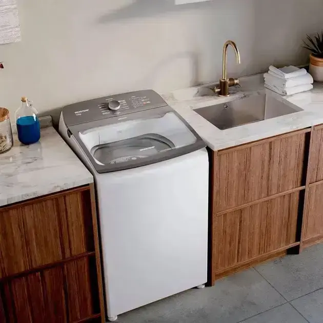 Lavadora de roupas, lateral, em ambiente interno com paredes claras e iluminação suave.